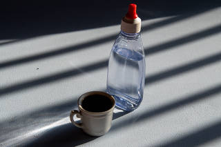 person sweetening coffee with liquid sweetener