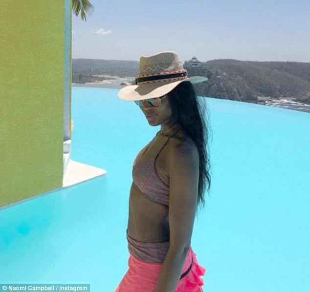 Happy days: The 47-year-old Londoner, who has worked in the fashion industry for nearly four decades, slipped into a chic mauve bikini with a high-waisted bottom while she shielded her face from the searing sun with a straw hat