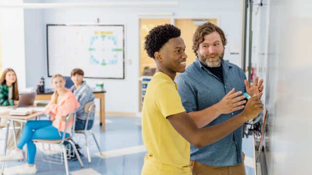 Student and teacher at a whiteboard in the classroom