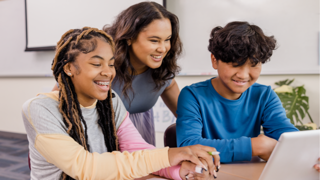 Students in a classroom looking at an iPad tablet