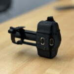 A black sensor sits on a wood table.